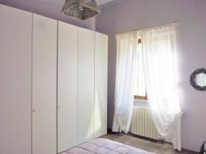 - une chambre avec un lit et une fenêtre avec des rideaux dans l'établissement La Casa dei Poeti, à Lerici