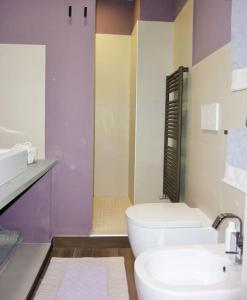 La salle de bains est pourvue de toilettes blanches et d'un lavabo. dans l'établissement La Casa dei Poeti, à Lerici
