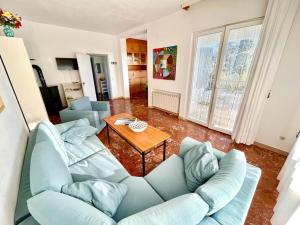 a living room with a blue couch and a table at Villa Renata, bellissima villa con terrazzo vista mare e spiaggia inclusa in Numana