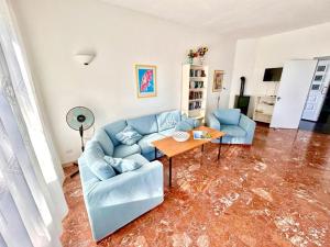 a living room with a blue couch and a table at Villa Renata, bellissima villa con terrazzo vista mare e spiaggia inclusa in Numana +30 photos