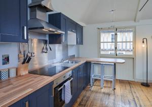 a kitchen with blue cabinets and a wooden floor at Studio 2 - Central Location Sleeps 4 in Norwich