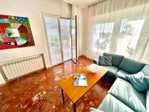 a living room with a couch and a table at Villa Renata, bellissima villa con terrazzo vista mare e spiaggia inclusa in Numana