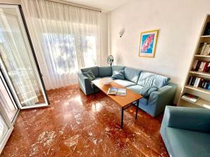 a living room with a blue couch and a table at Villa Renata, bellissima villa con terrazzo vista mare e spiaggia inclusa in Numana