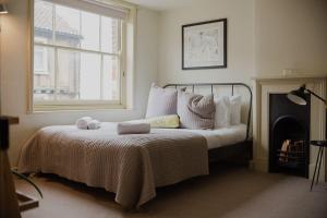 a bedroom with a bed with a fireplace and a window at Studio 2 - Central Location Sleeps 4 in Norwich