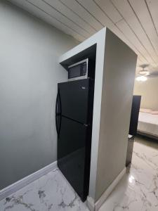 einen kleinen schwarzen Kühlschrank in einem Zimmer mit einer Wand in der Unterkunft Hollywood Beach Efficient in Hollywood