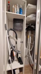 a room with two vacuum cleaners on a shelf at Cozy Apartment near Aura river in Turku