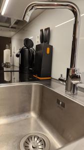 a kitchen sink with a mirror above it at Cozy Apartment near Aura river in Turku