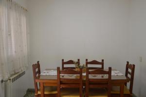einem Esstisch mit 4 Stühlen und einer weißen Wand in der Unterkunft Espacio de la Patagonia in Comodoro Rivadavia