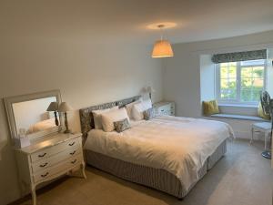 a bedroom with a bed and a mirror and a window at The Heritage Bed and Breakfast in Weymouth