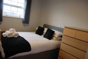um quarto com uma cama com almofadas pretas e brancas em Anchors Away by the Sea em Harwich