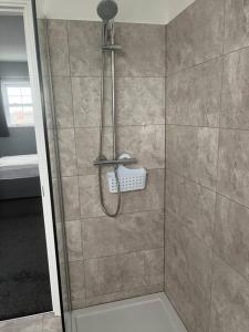 a shower with a shower head in a bathroom at Anchors Away by the Sea in Harwich