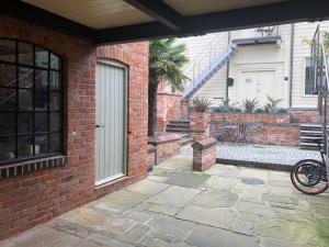 uma casa de tijolos com uma porta e um pátio em Studio 4- 6 Norwich City Centre Apartment em Norwich