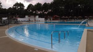 a large swimming pool with a water fountain at CHALET A NATURISTE Le TIKI in Le Porge