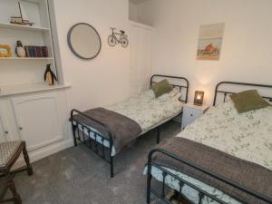 a bedroom with two beds and a mirror on the wall at Bay House in Bridlington