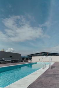 a swimming pool with a chair next to a building at UMA Suites Chia in Chía