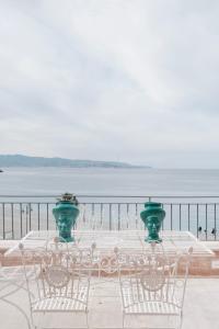 a table and chairs with a view of the water at La balza di Scilla in Scilla