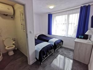 a bedroom with two beds and a toilet and a window at Plażowa 2 in Rowy