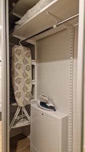 a white closet with a chair in a room at Riverside apartment with french balcony in Turku