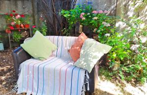 un sofá a rayas con almohadas sentado en un jardín en 2 personas, desayuno, gran ubicación, en Osorno