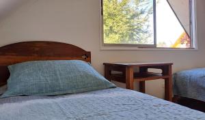 um quarto com uma cama, uma mesa e uma janela em 2 personas, desayuno, gran ubicación em Osorno