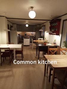 uma sala de estar com mesas e cadeiras e uma cozinha em Eikre Fjellgård em Hemsedal