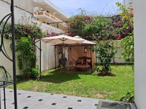 - une terrasse avec un parasol dans la cour dans l'établissement Casa Boutique Galvez, à Lima