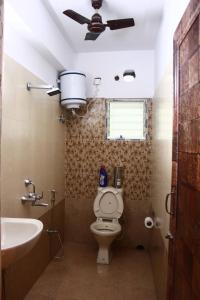 a bathroom with a toilet and a sink and a ceiling fan at LOTUS APARTMENTS HOTEL in kolkata