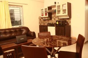 a living room with a table with a laptop on it at LOTUS APARTMENTS HOTEL in kolkata