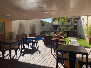un patio con mesas y sillas en una terraza en Excelente apto 1 dorm completo en Montevideo