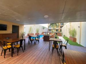 un patio con mesas y sillas y una piscina en Excelente apto 1 dorm completo en Montevideo