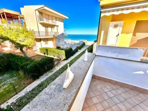 マルチェッリにあるMARZIO - appartamenti con terrazzo, posto auto e spiaggiaの海上の建物前のベンチ