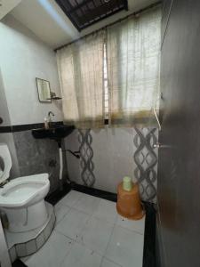 baño pequeño con aseo y ventana en Nishtha Guest House, en Ujjain