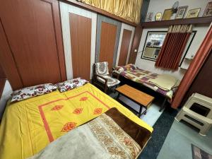 Habitación pequeña con cama, mesa y sillas en Nishtha Guest House, en Ujjain