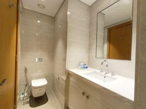 a bathroom with a toilet and a sink and a mirror at 3 BEDROOM APARTMENT ON MONTHLY RENT in Dubai