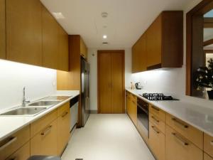 a kitchen with wooden cabinets and a sink at 3 BEDROOM APARTMENT ON MONTHLY RENT in Dubai
