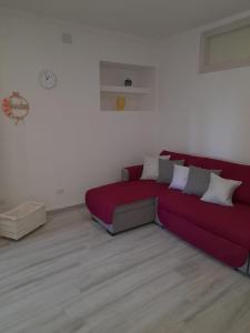 a living room with a red couch with pillows at Casa vacanze in centro! in Caltagirone