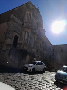 a white car parked in front of a building at Casa vacanze in centro! in Caltagirone