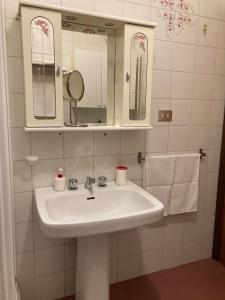 La salle de bains est pourvue d'un lavabo, d'un miroir et de serviettes. dans l'établissement Casa vacanze a pochi metri dal mare, à Grottammare