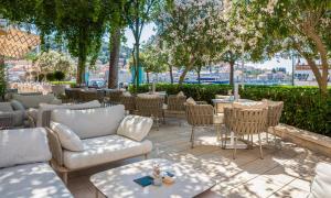 a patio with tables and chairs and trees at Aminess Younique Korcula Heritage Hotel in Korčula