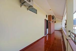 einen Flur mit rotem Fliesenboden und weißen Wänden in der Unterkunft Super OYO 92437 Wahidin Guesthouse in Pekalongan