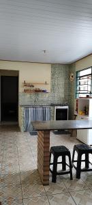 Casa Da Rua Da Pedra في ساو جوزيه دوس كامبوس: مطبخ مع طاولة و كرسيين