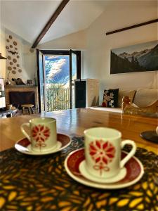 two cups and saucers sitting on a table at Baita Campo Felice in Collimento +21 photos