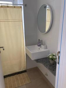 y baño con lavabo y espejo. en Apartamento céntrico en Mercedes Uruguay en Mercedes