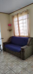 a blue couch in a room with a window at Casa Da Rua Da Pedra in São José dos Campos