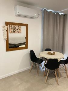 Apartamento céntrico en Mercedes Uruguay في مرسيدس: غرفة طعام مع طاولة وكراسي ومرآة