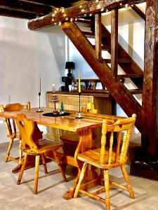a wooden dining room table with chairs and stairs at Baita Campo Felice in Collimento