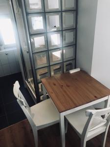 une table en bois et deux chaises blanches à côté d'une fenêtre dans l'établissement Studio near Lake, à Zurich