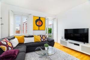 a living room with a black couch and a flat screen tv at WHome Beato Premium River View in Quiet Area in Lisbon