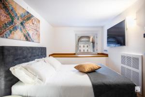 ein Schlafzimmer mit einem weißen Bett und einem Kissen darauf in der Unterkunft Urbanicooh Asinelli - Piazza Maggiore View in Bologna