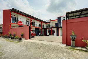 een rij rode en witte gebouwen in een straat bij SUPER OYO 3702 Homestay Bougenville Syariah in Lamongan